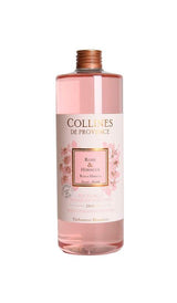 Collines de Provence Duftdiffuser-Nachfüllung Rose und Hibiskus in transparenter Flasche mit rosafarbener Flüssigkeit auf hellem Hintergrund.