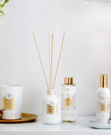 Collines de Provence Duftkollektion mit Duftkerze Baumwolle, Duftdiffuser Neroli, Duftdiffuser-Nachfüllung Neroli und Raumspray Baumwolle auf weißem Regal vor hellem Hintergrund.