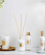 Collines de Provence Duftkollektion mit Duftkerze Baumwolle, Duftdiffuser Neroli, Duftdiffuser-Nachfüllung Neroli und Raumspray Baumwolle auf weißem Regal vor hellem Hintergrund.