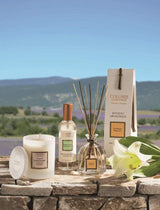 Collines de Provence Duftkerze, Raumspray und Duftdiffuser mit weißer Lilie auf einer Steinmauer vor einer Lavendellandschaft