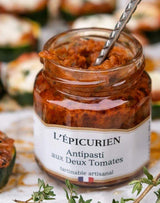 L'Épicurien Antipasti mit zweierlei Tomaten im geöffneten Glas mit Löffel in einer Servierszene.