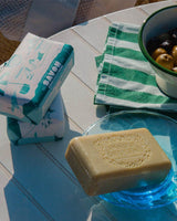 Panier des Sens feste Olivenölseife ausgepackt in Schale auf Strandtisch