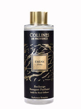 Collines de Provence Duftdiffuser-Nachfüllung Ebenholz in transparenter Flasche mit goldfarbenem Verschluss und schwarzem Etikett als Freisteller auf hellem Hintergrund.
