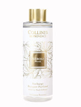 Collines de Provence Duftdiffuser-Nachfüllung Neroli in transparenter Flasche mit goldfarbenem Verschluss und weißem Etikett mit floralem Muster als Freisteller auf hellem Hintergrund.