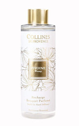 Collines de Provence Duftdiffuser-Nachfüllung Pfingstrose in transparenter Flasche mit goldfarbenem Verschluss und weißem Etikett mit floralem Muster als Freisteller auf hellem Hintergrund.