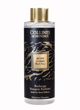 Collines de Provence Duftdiffuser-Nachfüllung Schwarze Rose in transparenter Flasche mit goldfarbenem Verschluss und schwarzem Etikett als Freisteller auf hellem Hintergrund.