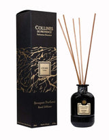 Collines de Provence Duftdiffuser Zeder mit schwarzen Duftstäbchen und schwarzer Glasflasche neben passender Produktverpackung auf hellem Hintergrund.