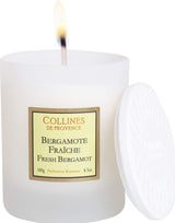 Collines de Provence Duftkerze Frische Bergamotte mit weißem Keramikdeckel und brennender Kerze.