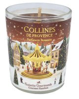 Collines de Provence Duftkerze Haselnuss 75gr im geöffneten Glas mit sichtbarem Holzdocht und weihnachtlich gestaltetem Etikett