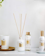 Collines de Provence Duftkollektion mit Duftkerze Baumwolle, Duftdiffuser Neroli, Duftdiffuser-Nachfüllung Neroli und Raumspray Baumwolle auf weißem Regal vor hellem Hintergrund.