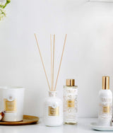 Collines de Provence Duftkollektion mit Duftkerze Baumwolle, Duftdiffuser Neroli, Duftdiffuser-Nachfüllung Neroli und Raumspray Baumwolle auf weißem Regal vor hellem Hintergrund.