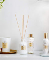 Collines de Provence Duftkollektion mit Duftkerze Baumwolle, Duftdiffuser Neroli, Duftdiffuser-Nachfüllung Neroli und Raumspray Baumwolle auf weißem Regal vor hellem Hintergrund.