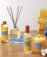 Collines de Provence Duftkollektion Neroli & Baumwollblüte mit Duftkerze, Duftdiffuser, Raumspray und Nachfüllung auf Holztisch arrangiert