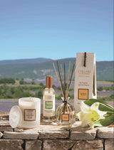 Collines de Provence Duftset mit Duftkerze Mandelblüte, Raumspray Weiße Lilie und Duftdiffusor Weiße Lilie vor Landschaftspanorama.