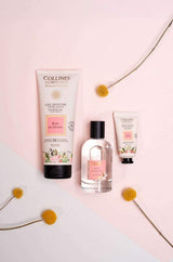 Collines de Provence Pflegeserie Rose von Grasse mit Duschgel, Eau de Toilette und Handcreme, dekorativ arrangiert mit gelben Blüten.