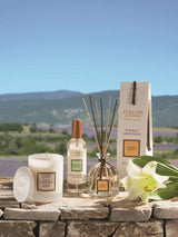 Collines de Provence Duftkerze, Raumspray und Duftdiffuser mit weißer Lilie auf einer Steinmauer vor einer Lavendellandschaft