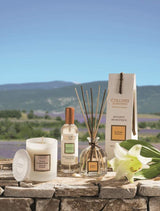Collines de Provence Duftkerze, Raumspray und Duftdiffuser mit weißer Lilie auf einer Steinmauer vor einer Lavendellandschaft