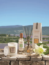 Collines de Provence Duftkerze, Raumspray und Duftdiffuser mit weißer Lilie auf einer Steinmauer vor einer Lavendellandschaft