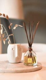 Collines de Provence Raumduftdiffuser Orientalisches Holz (100 ml) als stilvolles Dekoelement auf einem Marmortablett mit dunklen Duftstäbchen und einer Keramikvase für eine warme, elegante Wohnatmosphäre.