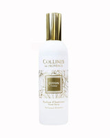 Collines de Provence Raumspray Baumwolle in weißer Flasche mit goldfarbenem Verschluss und floral gestaltetem Etikett als Freisteller auf hellem Hintergrund.