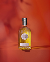 Château Estoublon Salonenque Olivenöl   in dekorativer Glasflasche vor rotem Hintergrund