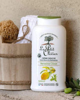 Le Petit Olivier Duschcreme Verbene-Zitrone neben einem Holzeimer mit Naturschwamm und Handtuch