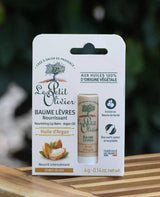Le Petit Olivier pflegender Lippenbalsam mit Arganöl in Kartonverpackung auf Holztisch