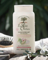 Le Petit Olivier Shampoo mit süßer Mandel und Reiscreme für normales Haar neben Haarbürste und Handtuch