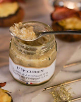 L'Épicurien Artischockencreme mit Périgord-Trüffel im geöffneten Glas mit Löffel in einer Servierszene.