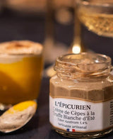 Geöffnetes Glas L'Épicurien Steinpilzcreme mit weißem Sommertrüffel in stimmungsvoller Servierszene.